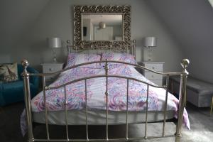 a bedroom with a bed with a mirror on the wall at St Duthus Hotel Apartment in Tain