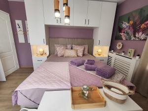 a bedroom with a large bed with purple walls at AMORE Obzor in Obzor