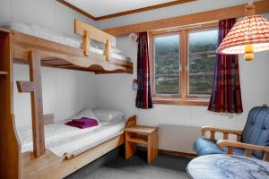 a small room with a bunk bed and a chair at Smuksjøseter Fjellstue in Høvringen