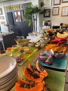 a table with plates and fruits and vegetables on it at Aram Yamí Boutique Hotel in Salvador