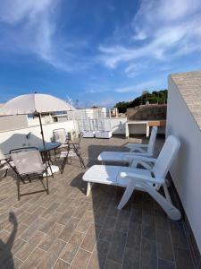 a patio with chairs and an umbrella on a roof at Casa Gina e Pietro in Ustica
