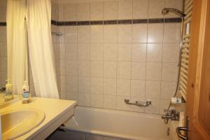 a bathroom with a sink and a tub and a shower at Residenza Lagrev 2 Zimmerwohnung Nr 005 - Typ 21A - Hochparterre - Süd in Sils Maria