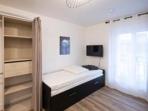 - une petite chambre avec un lit et une télévision dans l'établissement Résidence GABRIELLE, au Havre