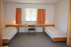 a room with two beds and a desk and a window at Residenza Lagrev 1 1 2 Zimmerwohnung Nr 007 - Typ 15A - Hochparterre - Süd in Sils Maria