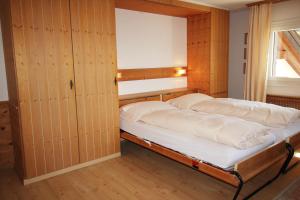 Ce lit se trouve dans un dortoir doté de murs en bois et d'une fenêtre. dans l'établissement Residenza Lagrev 1 Zimmerwohnung Nr 306 - Typ 12A - 3 Etage - Süd, à Sils-Maria