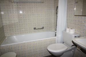 une salle de bain avec toilettes, baignoire et lavabo dans l'établissement Residenza Lagrev 1 Zimmerwohnung Nr 306 - Typ 12A - 3 Etage - Süd, à Sils-Maria