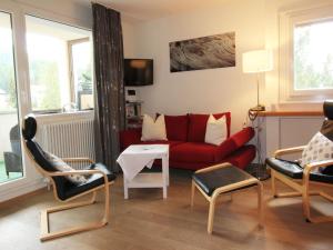 - un salon avec un canapé et des fauteuils rouges dans l'établissement Residenza Lagrev 2 Zimmerwohnung Nr 102 - Typ 21A - 1 Etage - Süd, à Sils-Maria