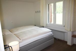 - un lit blanc dans une chambre avec fenêtre dans l'établissement Residenza Lagrev 2 Zimmerwohnung Nr 102 - Typ 21A - 1 Etage - Süd, à Sils-Maria