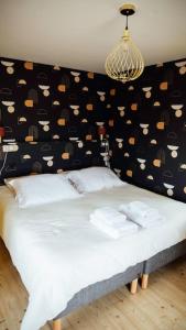 um quarto com uma cama com uma parede preta com chapéus em Gîte Trou Life em Bozouls
