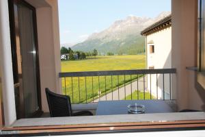 a balcony with a table and a view of a field at Residenza Lagrev 1 Zimmerwohnung Nr 128 - Typ 12B - 1 Etage - Ost in Sils Maria