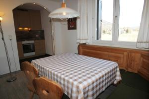 a kitchen with a table with a checkered table cloth at Residenza Lagrev 2 Zimmerwohnung Nr 117 - Typ 20A - 1 Etage - Süd in Sils Maria