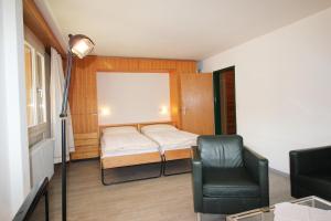 a small bedroom with a bed and a chair at Residenza Lagrev 2 Zimmerwohnung Nr 117 - Typ 20A - 1 Etage - Süd in Sils Maria