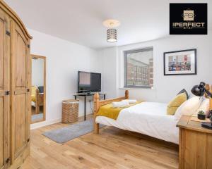 a bedroom with a bed and a flat screen tv at Imperial Central By Your Perfect Stay Short lets Birmingham in Birmingham