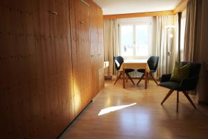 um quarto com cadeiras, uma mesa e uma janela em Residenza Lagrev 1 Zimmerwohnung Nr 227 - Typ 11B - 2 Etage - Ost em Sils Maria