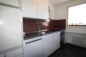 una cucina bianca con lavandino e finestra di Residenza Lagrev 2 Zimmerwohnung Nr 211 - Typ 20A - 2 Etage - West a Sils Maria