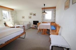 een slaapkamer met een bed, een tafel en een bank bij Residenza Lagrev 2 Zimmerwohnung Nr 212 - Typ 21B - 2 Etage - S W in Sils Maria