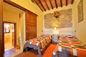 2 Betten in einem Zimmer mit einer Steinmauer in der Unterkunft Francesca 2 Senior suite Villa Ricetro in Luciano