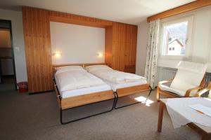 een slaapkamer met een bed, een stoel en een raam bij Residenza Lagrev 2 Zimmerwohnung Nr 212 - Typ 21B - 2 Etage - S W in Sils Maria