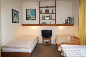 a room with two beds and a tv in it at Residenza Lagrev Studio Nr 113 - Typ 10A - 1 Etage - Ost in Sils Maria
