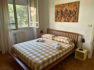 Appartamento Accademia في ليفورنو: غرفة نوم مع سرير مع اثنين من الحيوانات المحشوة عليه