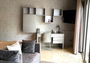ein Wohnzimmer mit einem Schreibtisch und einem Sofa in der Unterkunft Villa Majestueuse 5 étoiles à Casablanca in Casablanca