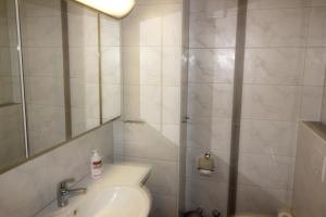 ein Badezimmer mit einem Waschbecken, einem WC und einem Spiegel in der Unterkunft Residenza Lagrev 1 Zimmerwohnung Nr 228 - Typ 11A - 2 Etage - Ost in Sils Maria