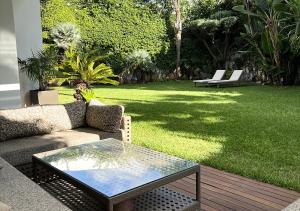 une terrasse avec un canapé, une table et une pelouse dans l'établissement Villa Majestueuse 5 étoiles à Casablanca, à Casablanca