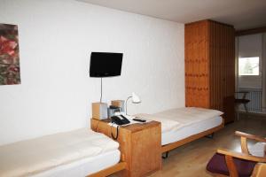 錫爾斯瑪利亞的住宿－Residenza Lagrev Studio Nr 224 - Typ 10B - 2 Etage - Ost，客房设有两张床和一台墙上的电视。