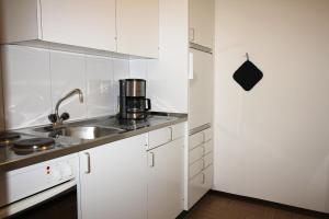 una cocina con armarios blancos y fregadero en Residenza Lagrev 2 Zimmerwohnung Nr 112 - Typ 21B - 1 Etage - Süd, en Sils-Maria