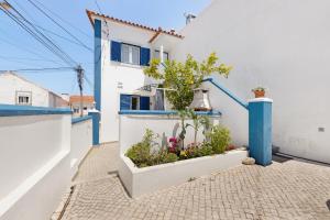 ein Haus mit blauen und weißen Wänden und Pflanzen in der Unterkunft Casa Lomba in Colares