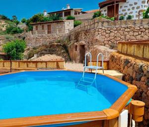 a large blue pool with a chair next to a stone wall at La Casita de Tila in Ifonche