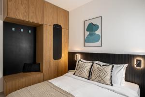 een slaapkamer met een bed met een houten hoofdeinde bij Mate GEORGE - By HOMY in Tel Aviv