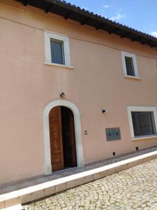 a house with a brown door and windows at Casa Collarano in San Demetrio neʼ Vestini