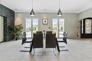 a dining room with a glass table and chairs at *Villa-Disneyland-Paris* 10pers, Fitness, Cinema in Gouvernes
