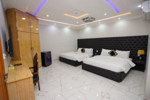 een hotelkamer met 2 bedden en een televisie bij Hotel Orange One in Lahore