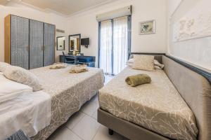 a bedroom with two beds and a desk at Royal Boutique Hotel NUOVA GESTIONE in Riccione +158 photos