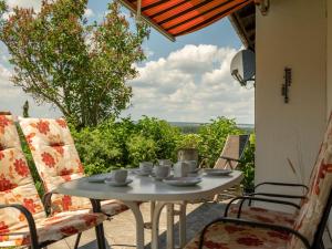 - une table et des chaises sur une terrasse avec vue dans l'établissement Holiday Home Schöne Aussicht by Interhome, à Dittishausen