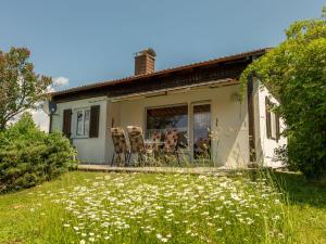 ein weißes Haus mit einem Tisch und Stühlen im Hof in der Unterkunft Holiday Home Schöne Aussicht by Interhome in Dittishausen