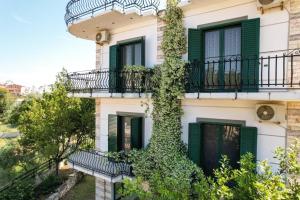 a building with green shutters and a balcony at Sea La Vie Apartments in Ksamil