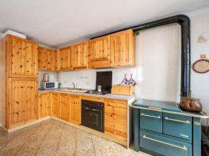een keuken met houten kasten en een zwarte vaatwasser bij Holiday Home Maison Baulin by Interhome in Baulen