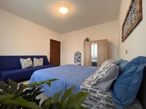 een slaapkamer met een blauw bed en een bank bij Ornella's apartment - Relax near Venice 
