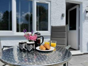 a table with a plate of croissants and drinks on it at Little Greenway Holiday Bungalow in Galmpton-on-the-Dart