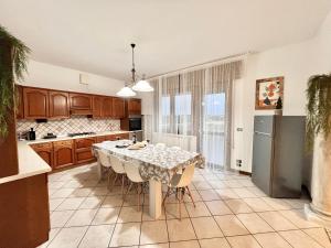 een keuken met een tafel met stoelen en een koelkast bij Ornella's apartment - Relax near Venice 