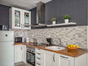 - une cuisine avec des placards blancs et un plan de travail avec un évier dans l'établissement Apartment Apartamento Duquesa de España-1 by Interhome, à Torremolinos