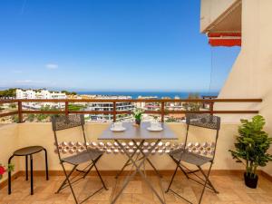 un tavolo e sedie su un balcone con vista sull'oceano di Apartment Apartamento Duquesa de España-1 by Interhome a Torremolinos
