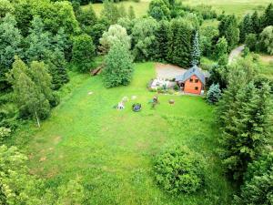 une vue aérienne sur un grand champ herbeux avec une maison dans l'établissement Wierzbowy Jar - Natura Spokój Sauna Kominek Karkonosze, à Janowice Wielkie