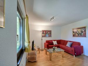 - un salon avec un canapé rouge et une table dans l'établissement Apartment Fieke by Interhome, à Frankenau