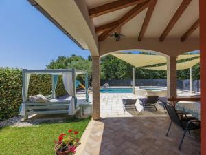 eine Terrasse mit einer Schaukel und einem Pool in der Unterkunft Holiday Home Villa Amaii by Interhome in Karigador