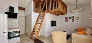 un soggiorno con scala in legno in una camera di Appartement en bord de mer 3 a Banyuls-sur-Mer