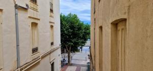un vicolo tra due edifici con un albero in lontananza di Appartement en bord de mer 3 a Banyuls-sur-Mer 1 altra foto